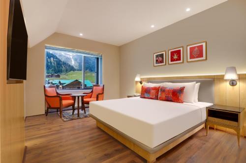 a bedroom with a large bed and a dining room at Lemon Tree Hotel, Sonamarg in Sonāmarg