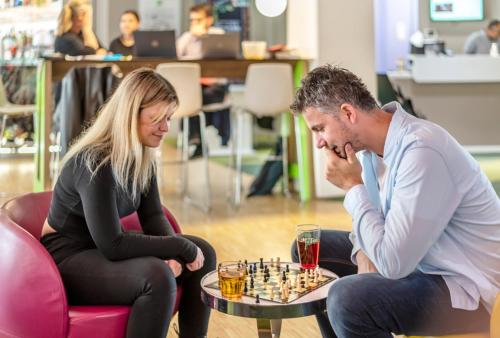 a man and a woman playing a game of chess at ibis Styles Strasbourg Stade de la Meinau in Strasbourg