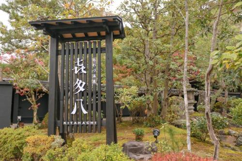 un cartello in mezzo a un giardino di Awazuonsen Kitahachi a Komatsu