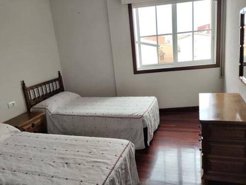 a room with two twin beds and a window at Piso en Grove in O Grove