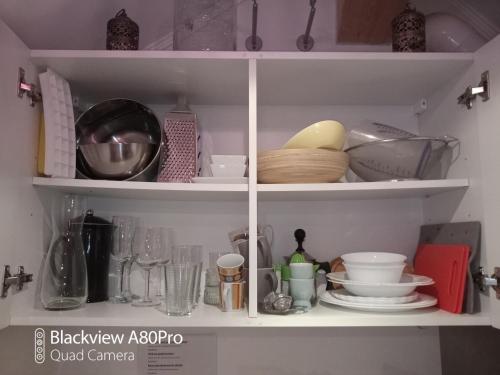 a kitchen shelf filled with dishes and utensils at Um Burebierg apartment 35m2 in Buschrodt