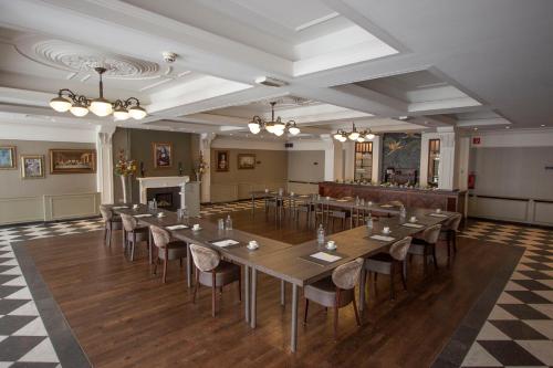ヘルモントにあるGolden Tulip West Endeの長いテーブルと椅子が備わる広い客室です。