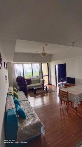 a living room with a couch and a table at Splendido Tagaytay Taal Lake Staycation Free Parking Netflix No Free Pool in Tagaytay