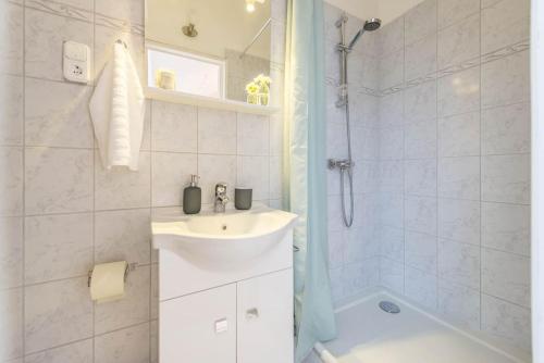 a white bathroom with a sink and a shower at Venus Apartments - Skylit - Deluxe Loft with Skylight in Budapest