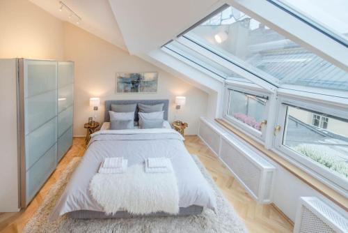 a bedroom with a large bed with a large window at Venus Apartments - Skylit - Deluxe Loft with Skylight in Budapest