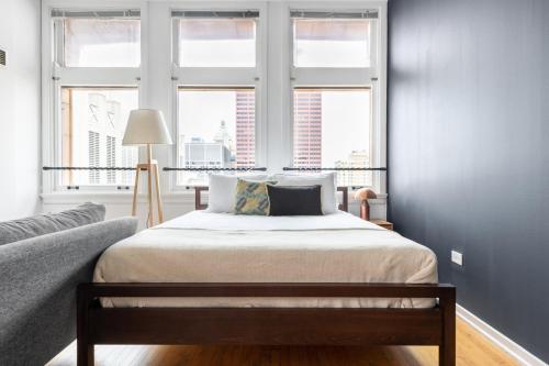 een slaapkamer met een bed en twee ramen bij Loop Studio w Gym Doorman nr L Parks CHI-300 in Chicago