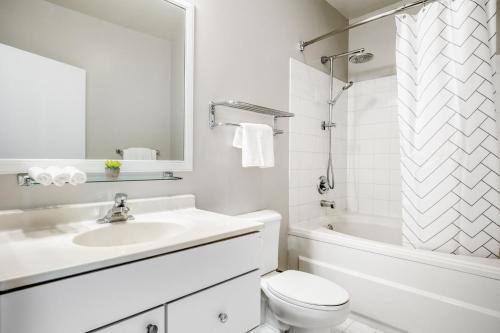 een witte badkamer met een wastafel, een toilet en een bad bij Loop Studio w Gym Doorman nr L Parks CHI-300 in Chicago