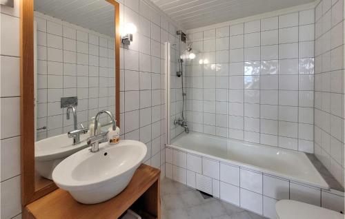a bathroom with a sink and a bath tub at 4 Bedroom Awesome Home In Strandvik 