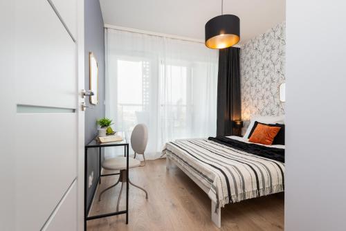 una camera da letto con un letto e una scrivania con una sedia di Kairos Apartments -Tower II Premium - darmowy parking, siłownia, sauna - ścisłe centrum a Katowice