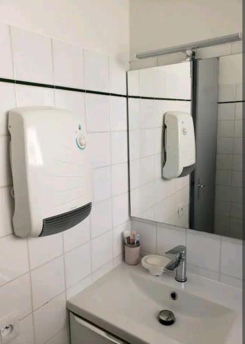 La salle de bains est pourvue d'un lavabo et d'un distributeur de savon sur le mur. dans l'établissement VUE PANORAMIQUE SUR LES PYRÉNÉES, à Saint-Lary-Soulan