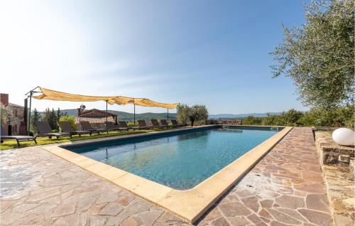 een zwembad met een patio en een parasol bij Gorgeous Home In Montegabbione Tr With Kitchen in Montegabbione