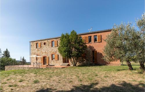 a large brick house with trees in front of it at Corte Liliana in Montegabbione