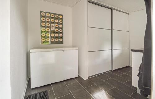 a kitchen with white cabinets and a tile floor at Holiday Home Hodde With Fireplace in Tistrup