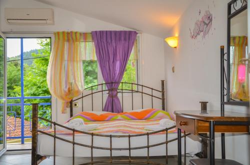 Schlafzimmer mit einem Bett und einem Fenster mit lila Vorhängen in der Unterkunft Studios Ifigenia in Skala Potamias