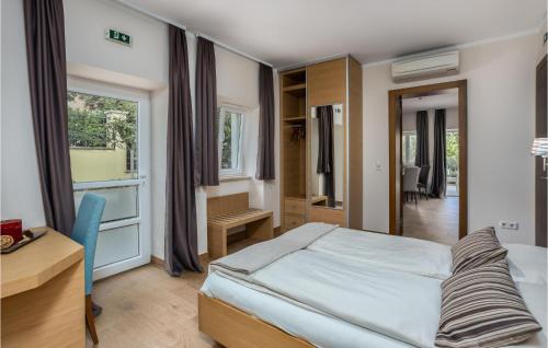 1 dormitorio con cama, escritorio y ventana en Amazing Apartment In Crikvenica With Outdoor Swimming Pool, en Crikvenica