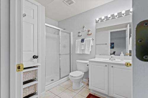 a white bathroom with a toilet and a sink at Quietside in Camdenton
