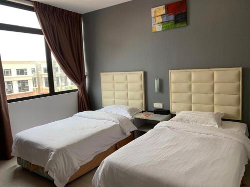 2 camas en una habitación con ventana en Fortune Hotel en Johor Bahru