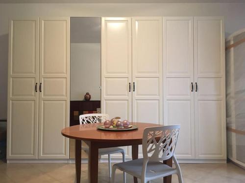 a dining room with a table and chairs and white cabinets at Vacation home Controra, Ginosa (TA) in Ginosa