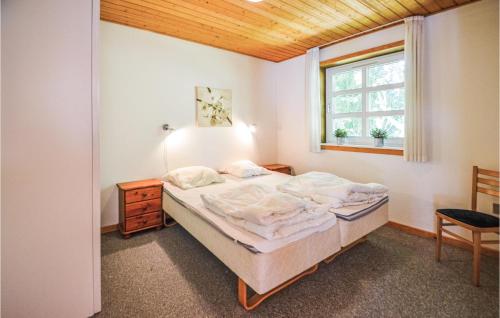 8 Bedroom Nice Home In ster Assels في Sillerslev: غرفة نوم بسرير ونافذة