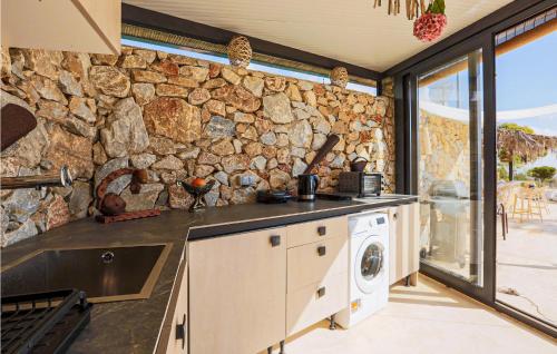 Una pared de piedra en una cocina con lavadora y secadora. en Stunning Home In Murcia With Swimming Pool, en Murcia