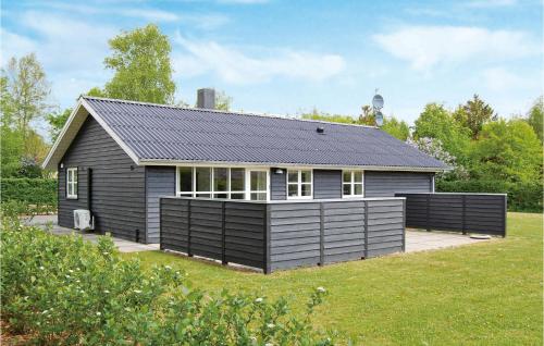 a black house with a solar roof on a yard at Holiday Home Søgårdsvej Ansager X in Ansager