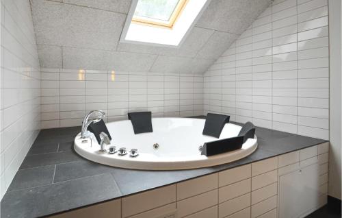 a bath tub in a bathroom with a skylight at Awesome Home In Hjerm With Wifi in Hjerm