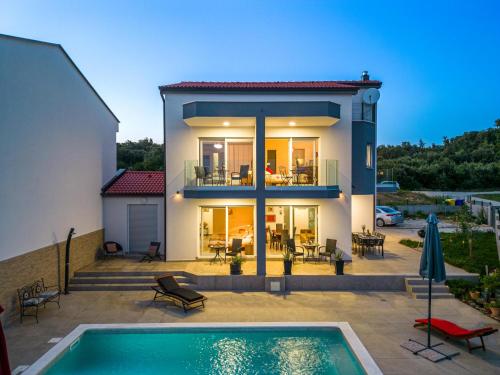 a house with a swimming pool in front of it at Villa Rozeta in Marčana
