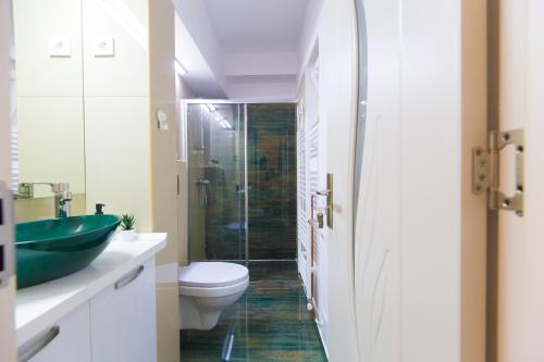 Un baño con inodoro y ducha de cristal. en Best room, en Bucarest