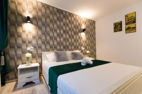 Un dormitorio con una gran cama blanca y una pared. en Best room, en Bucarest
