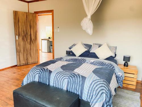 Schlafzimmer mit einem Bett mit einer blauen und weißen Bettdecke in der Unterkunft Porcupine Cabin in Palatswe