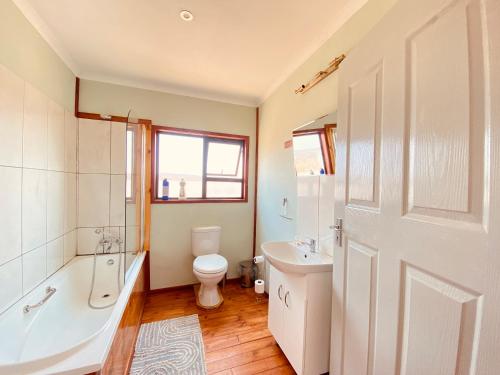 La salle de bains est pourvue d'une baignoire, de toilettes et d'un lavabo. dans l'établissement Porcupine Cabin, à Palatswe