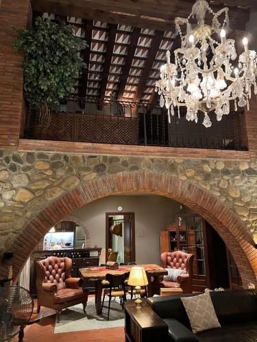 a large living room with a chandelier and a stone wall at Villa Sol Luxury Costa Brava Golf in Peralada