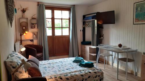 1 dormitorio con cama, mesa y escritorio en Le Bois gentil, en Foncine-le-Haut