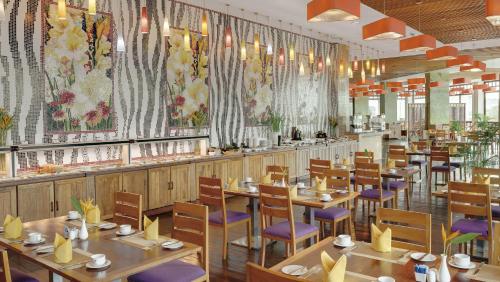 a restaurant with wooden tables and chairs and flowers on the walls at Sokha Phnom Penh Residence in Phnom Penh