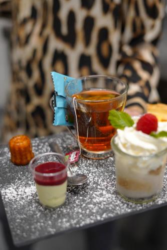 a table topped with two desserts and a drink at Best Western l'Atelier 117 in Maubeuge