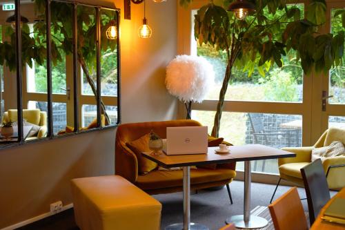 a room with a table and a chair and a laptop at Best Western l'Atelier 117 in Maubeuge
