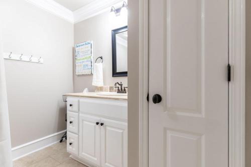 een witte badkamer met een wastafel en een spiegel bij Bryant in Little Rock