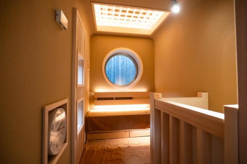 a hallway with a round window and a ceiling at UreshinoOnsen URESHINO YADOYA in Ureshino