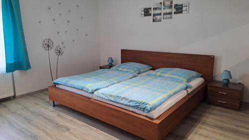 una camera con letto in legno e 2 cuscini di Ferienwohnungen Denk a Niederalteich