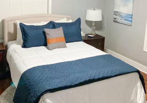 - une chambre avec un lit et des oreillers bleus dans l'établissement Oak Forest Cottage, à Little Rock