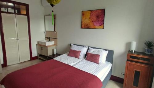 a bedroom with a large bed with a red blanket at Casa Ciska in Redinha