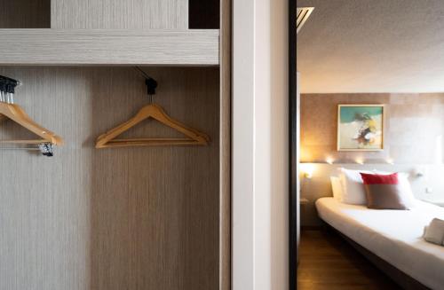 a hotel room with a bed and a bed and a closet at Best Western l'Atelier 117 in Maubeuge