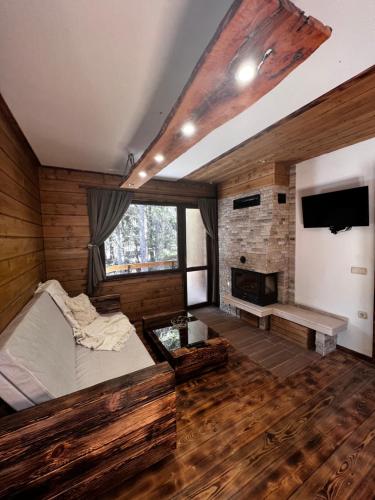 a large room with a bed and a fireplace at Райски кът “Еленова поляна” in Dobărsko
