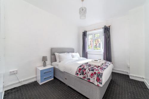 a white bedroom with a bed and a window at Hidden Gem, Bright 1BR flat wPatio in Lambeth in London