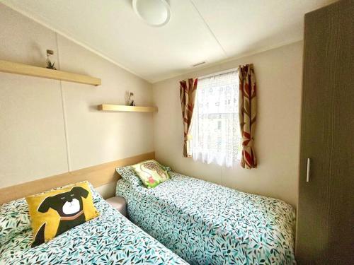 una piccola camera con due letti e una finestra di Free Spirit - Landscove Holiday Park in Brixham a Brixham