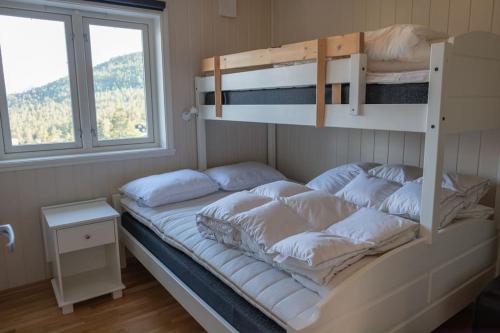 ein Etagenbett mit Kissen darauf in einem Schlafzimmer in der Unterkunft Mountain Lodge by Homes & Villas in Stryn