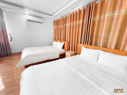 a hotel room with two beds and a window at HAAP Transit Hotel in Noi Bai