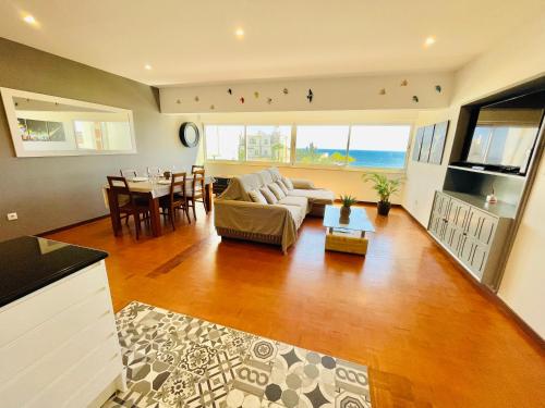 ein Wohnzimmer mit einem Sofa und einem Tisch in der Unterkunft Paraíso - Beachfront - Private Parking in Portimão