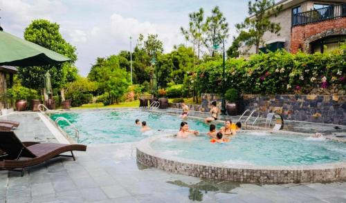 eine Gruppe von Menschen, die in einem Schwimmbad spielen in der Unterkunft An Villa Venuestay in Tam Ðảo