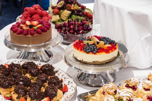 a table with cakes and other desserts on plates at Klækken Hotel in Hønefoss